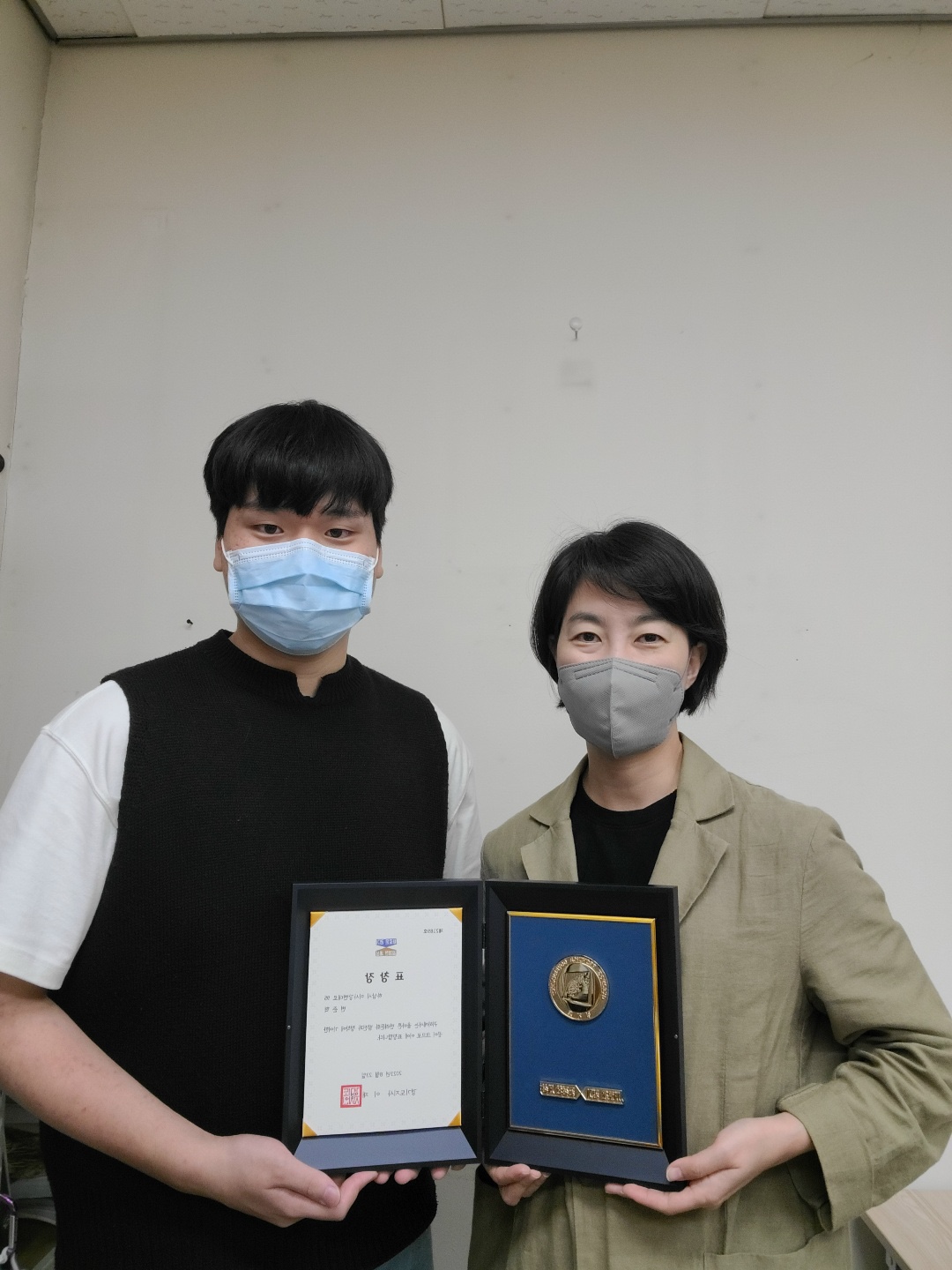 변준혁 학생 과 조윤주 교수님이 상장을 들고 사진을 찍고 있는 모습