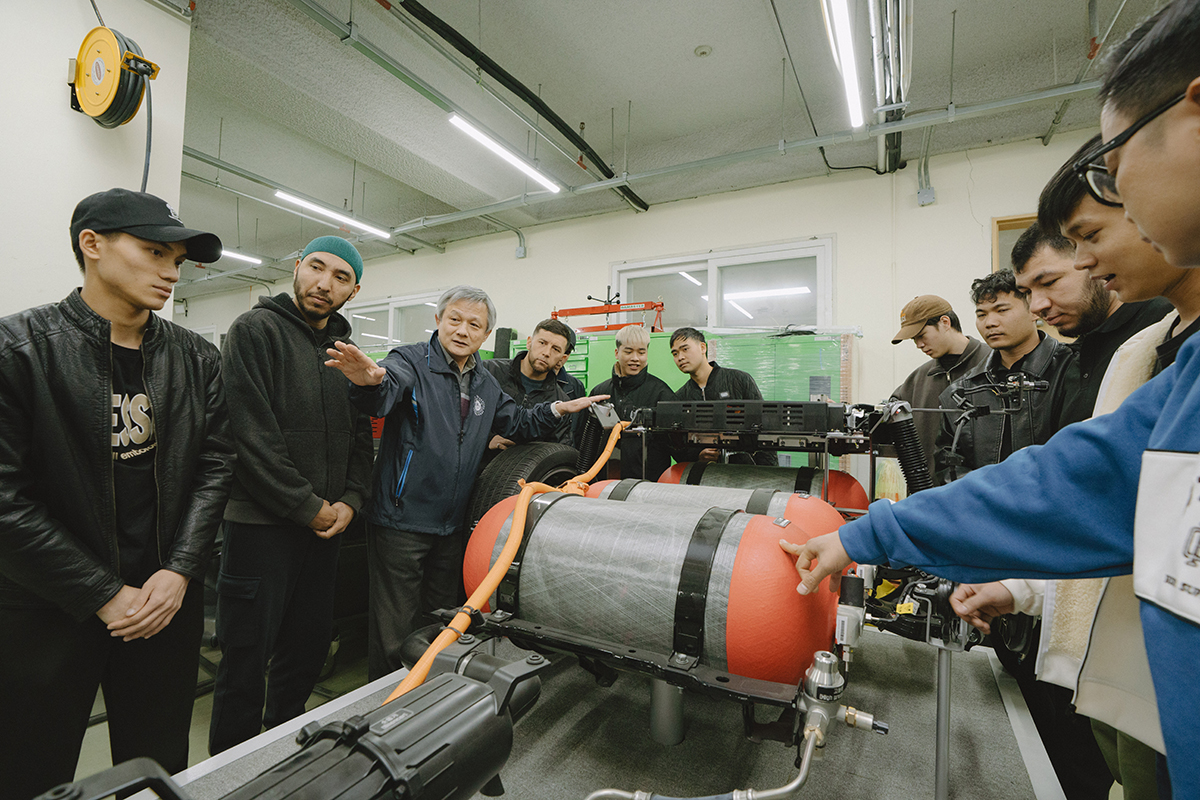자동차 부품을 보며 교수님의 설명을 듣고 있는 학생들