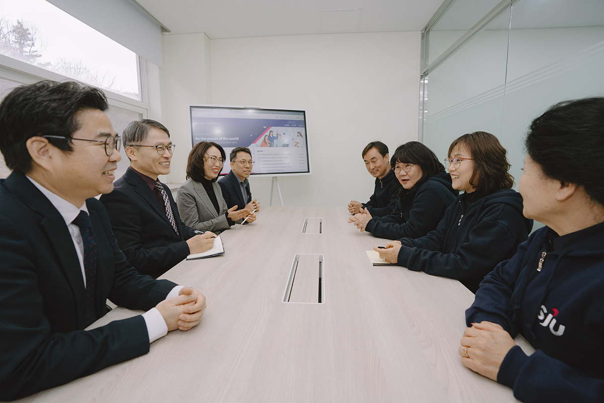 교수님들과 학생들이 회의실에서 대화를 하고 있다.