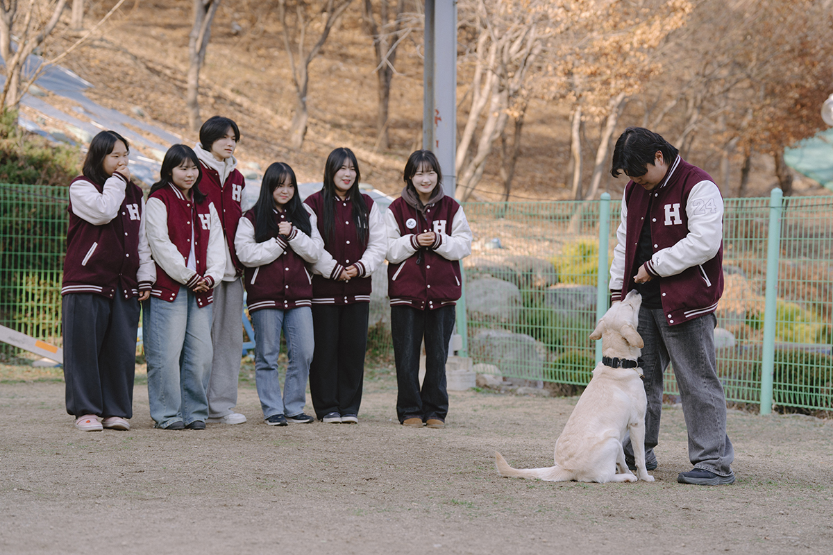 과 점퍼를 입고 각각 리트리버를 교육시키고 있는 모습