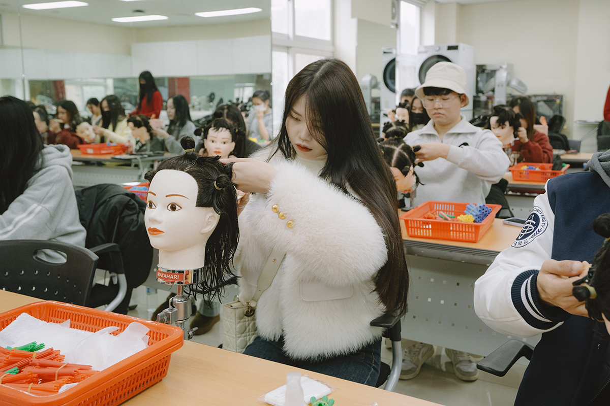 교수님께 미용실습을 지도받는 학생들