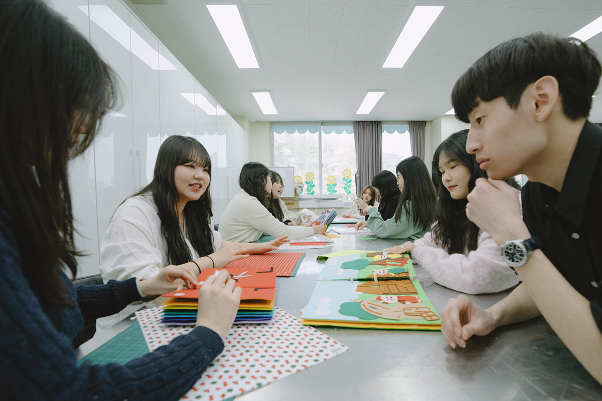 학생들이 서로 동화책 읽어주는 실습을 하고 있는 사진