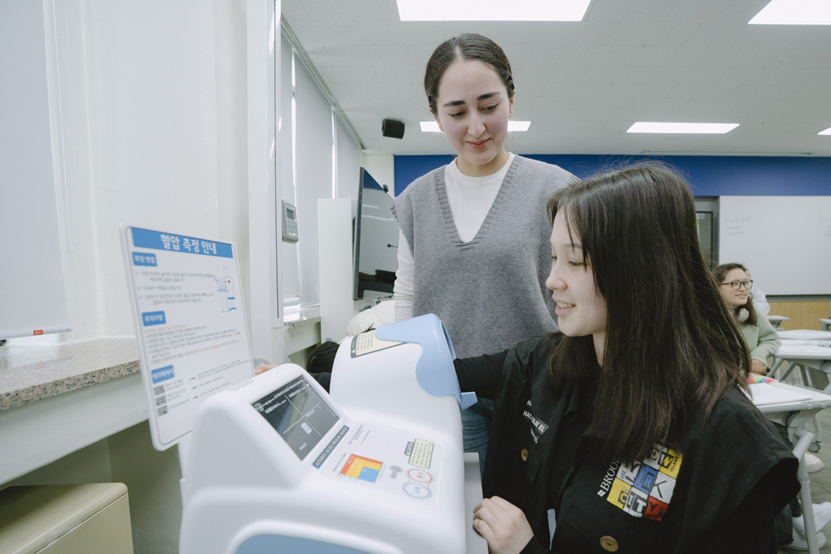 의료기구 앞에서 설명하는 교수님과 집중하는 학생