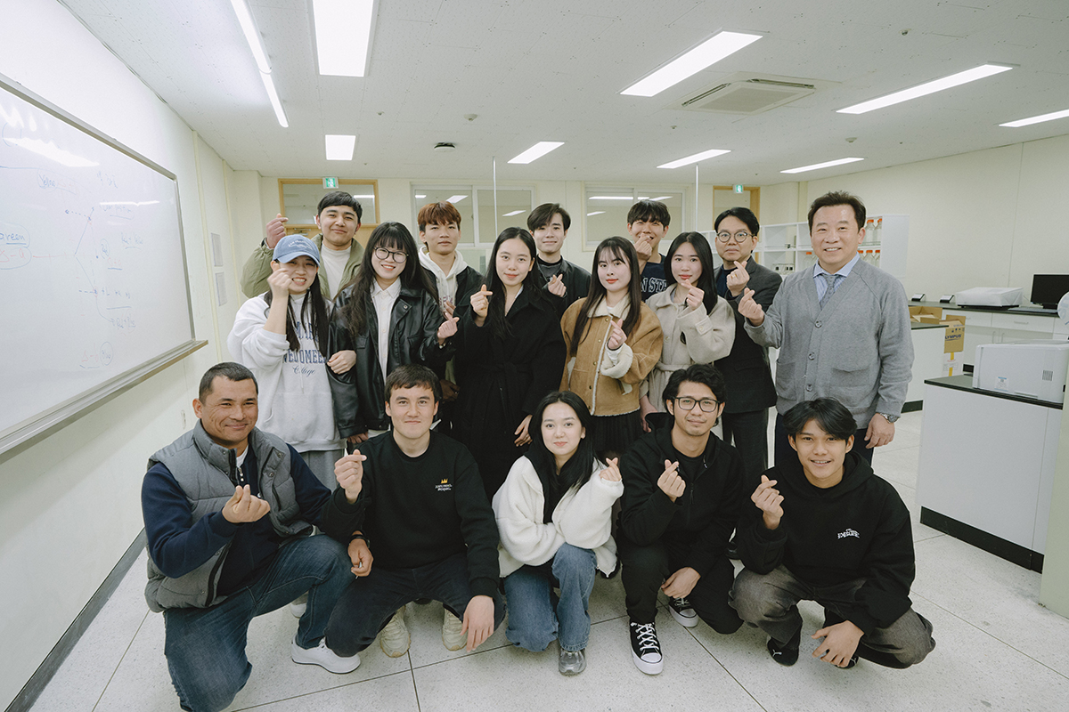 교수님과 학생들이 실습실에서 단체 사진을 찍고 있다.